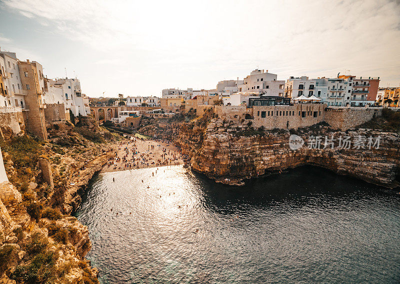 在阳光明媚的日子里，海边岩石悬崖上的住宅建筑与天空的对比。Polignano a Mare